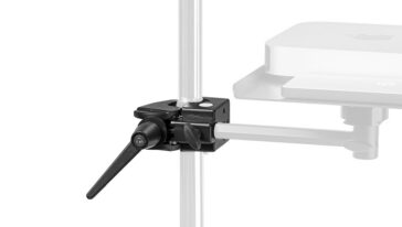 Close-up of a black adjustable clamp securing a horizontal arm to a vertical metal pole on a stand, part of a mounting rig.
