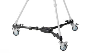 Four-wheeled camera dolly with a central hub and four swivel casters on a black metal frame.