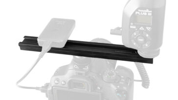 DSLR camera mounted on a horizontal rail with a PocketWizard Plus wireless trigger plugged in.