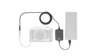 Camera connected to an external battery pack via a power adapter and cable, powering the camera setup