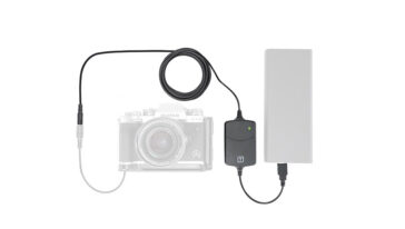 Camera connected to an external battery pack via a power adapter and cable, powering the camera setup