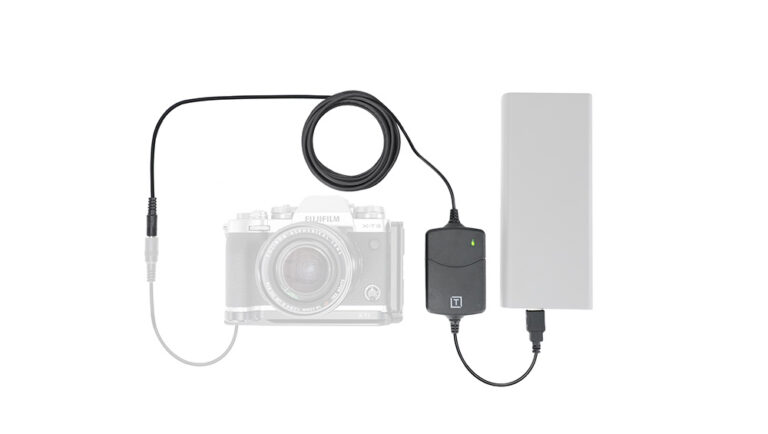 Camera connected to an external battery pack via a power adapter and cable, powering the camera setup