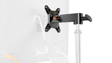 Monitor attached to a wall/desk mount arm with adjustable pole (Tether Tools branding visible).