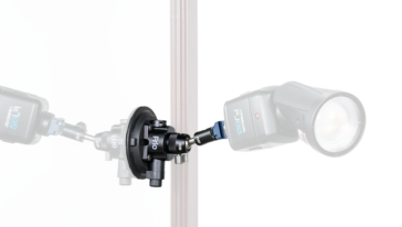 Two studio strobes mounted on a central clamp around a vertical stand, facing outward symmetrically.