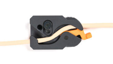 Plastic wire clamp gripping a beige electrical wire
