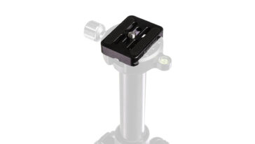 Black quick-release plate mounted on top of a silver tripod head.