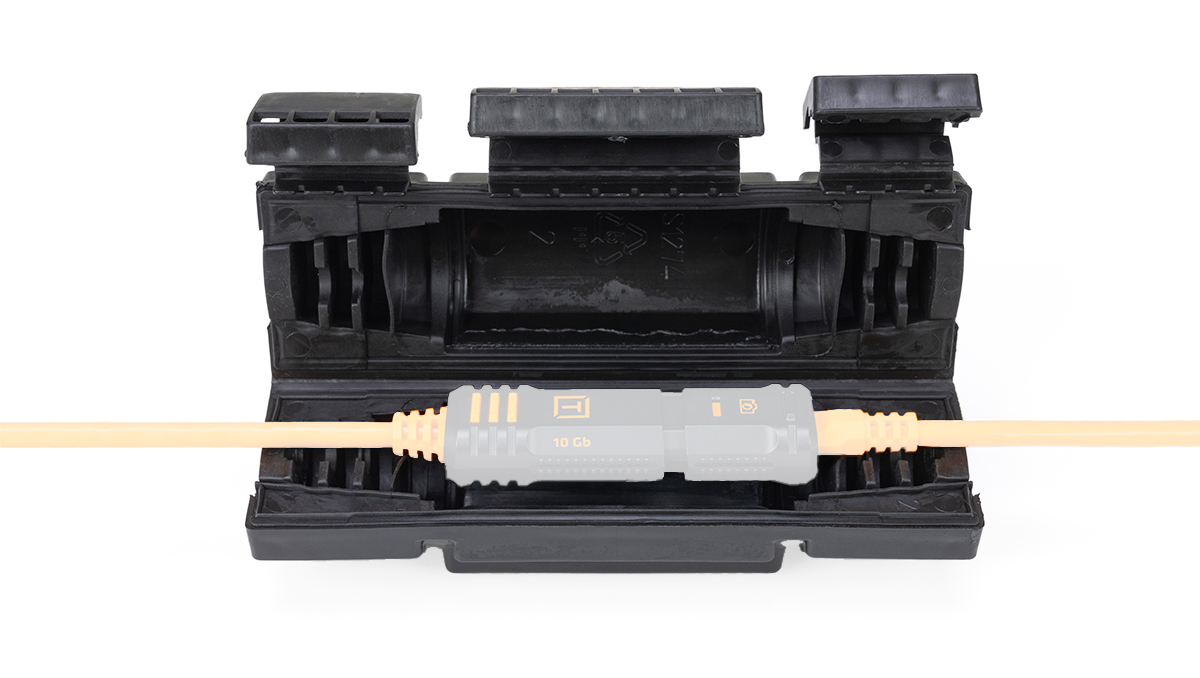 Orange fiber optic cable plugged into a gray 10 Gb connector resting in a black protective case.