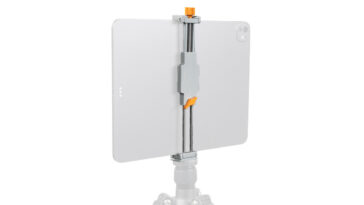 Tablet attached to a vertical clamp mount on a tripod with orange adjustment knobs, used for stable filming or photography setups.