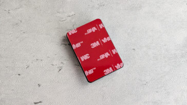 Red square 3M VHB adhesive pad on a light gray background.